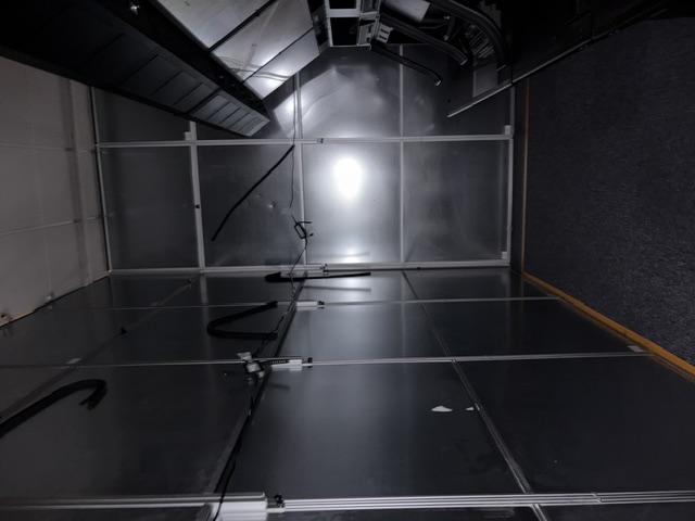 Interior corner of a tall modular containment wall installed beside equipment in an active FAA control room.