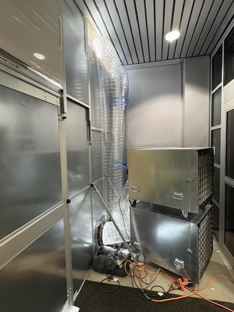 HEPA air scrubbers and flexible ducting operating inside the negative-air containment enclosure.