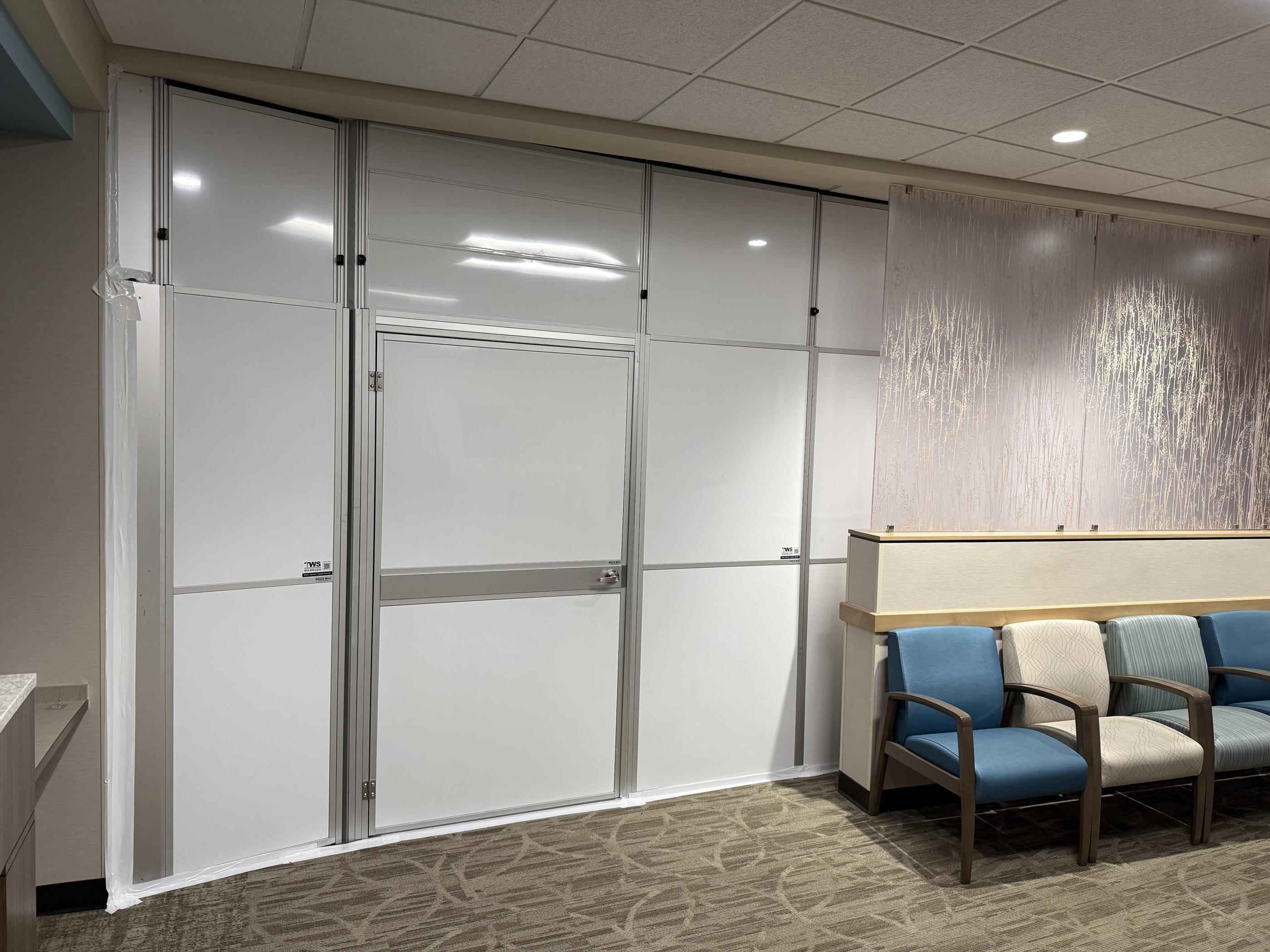 Close view of modular healthcare containment and an access door fitted between the reception area and waiting room seating.