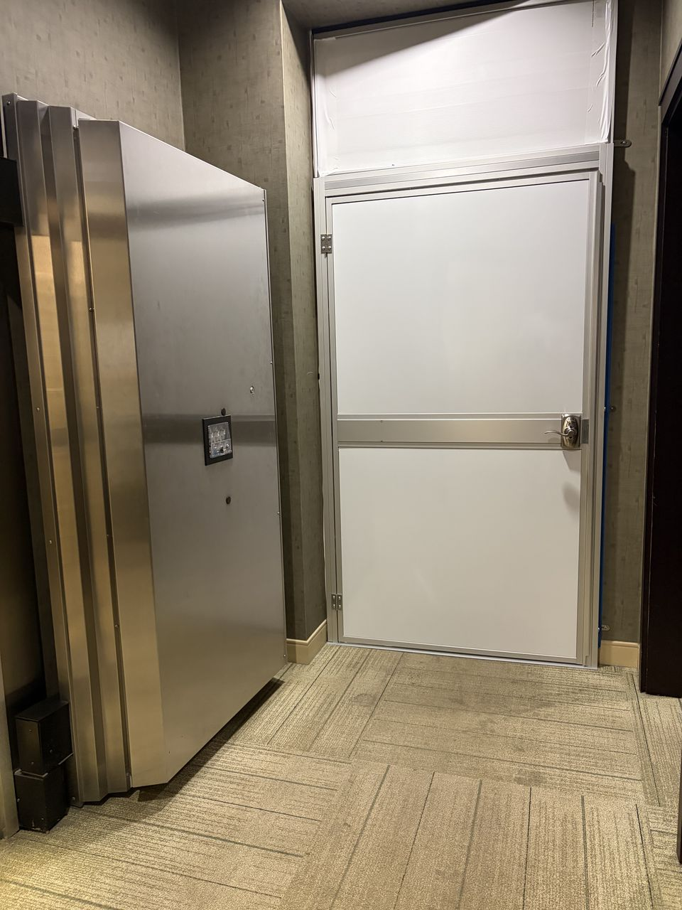 Integrated access door within a Temporary Wall Systems modular hard wall containment installation used to separate active banking operations from construction work.