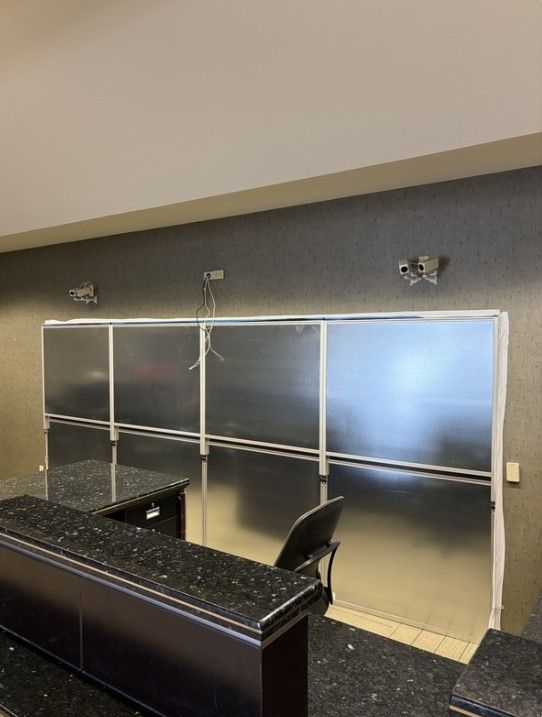 Custom modular hard wall containment installed behind a banking workstation at Legacy Bank, creating secure construction containment during an occupied renovation project.