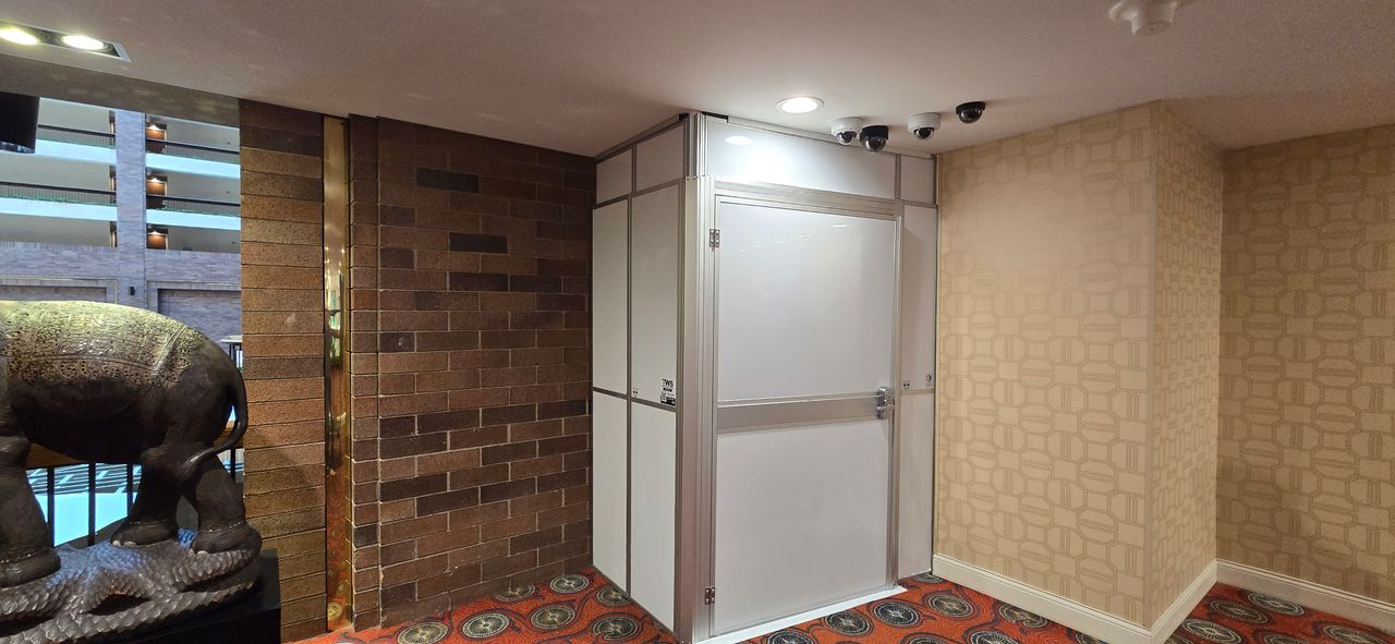 Temporary Wall Systems modular hard wall containment with a secure access door installed at the Hilton Anatole to separate renovation work from occupied hotel spaces.
