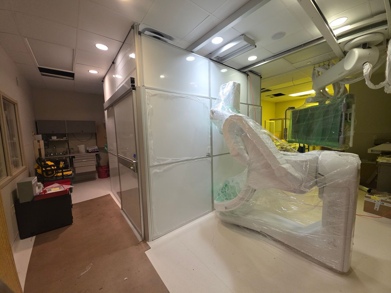 Modular hard wall containment surrounding medical imaging equipment inside a hospital, providing healthcare construction containment while renovation work continues safely nearby.