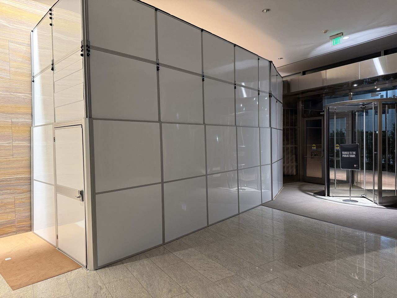 Modular hard wall containment installed alongside an active office tower entrance, providing construction containment while preserving safe pedestrian access during a healthcare build-out.