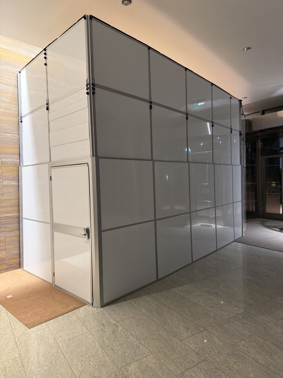 Temporary construction walls forming a fully enclosed freestanding containment system that maintains lobby access during a healthcare renovation in an occupied commercial building.