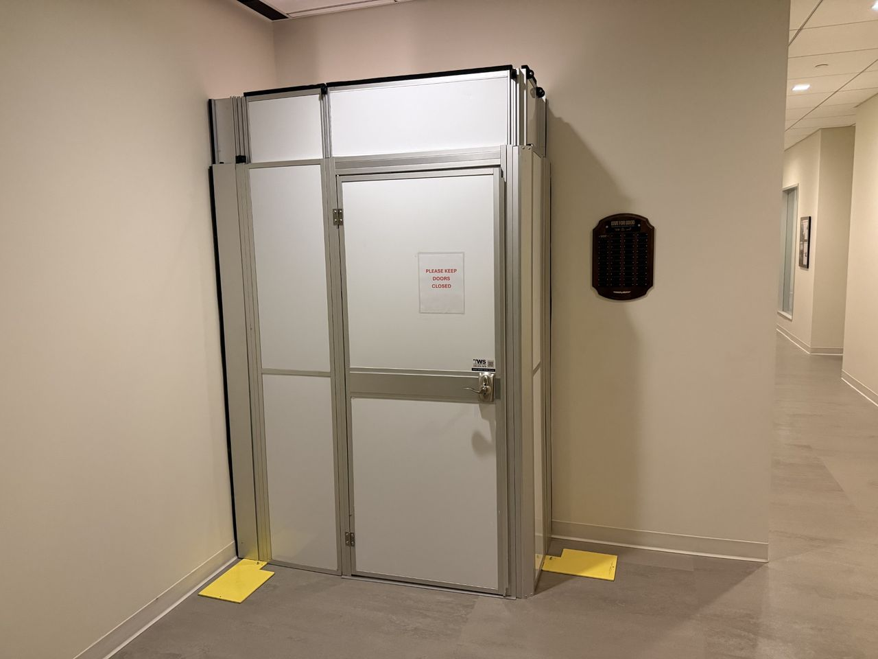Temporary Wall Systems modular hard wall containment with a secure locking door installed in an office building stairwell to control access during an occupied renovation.