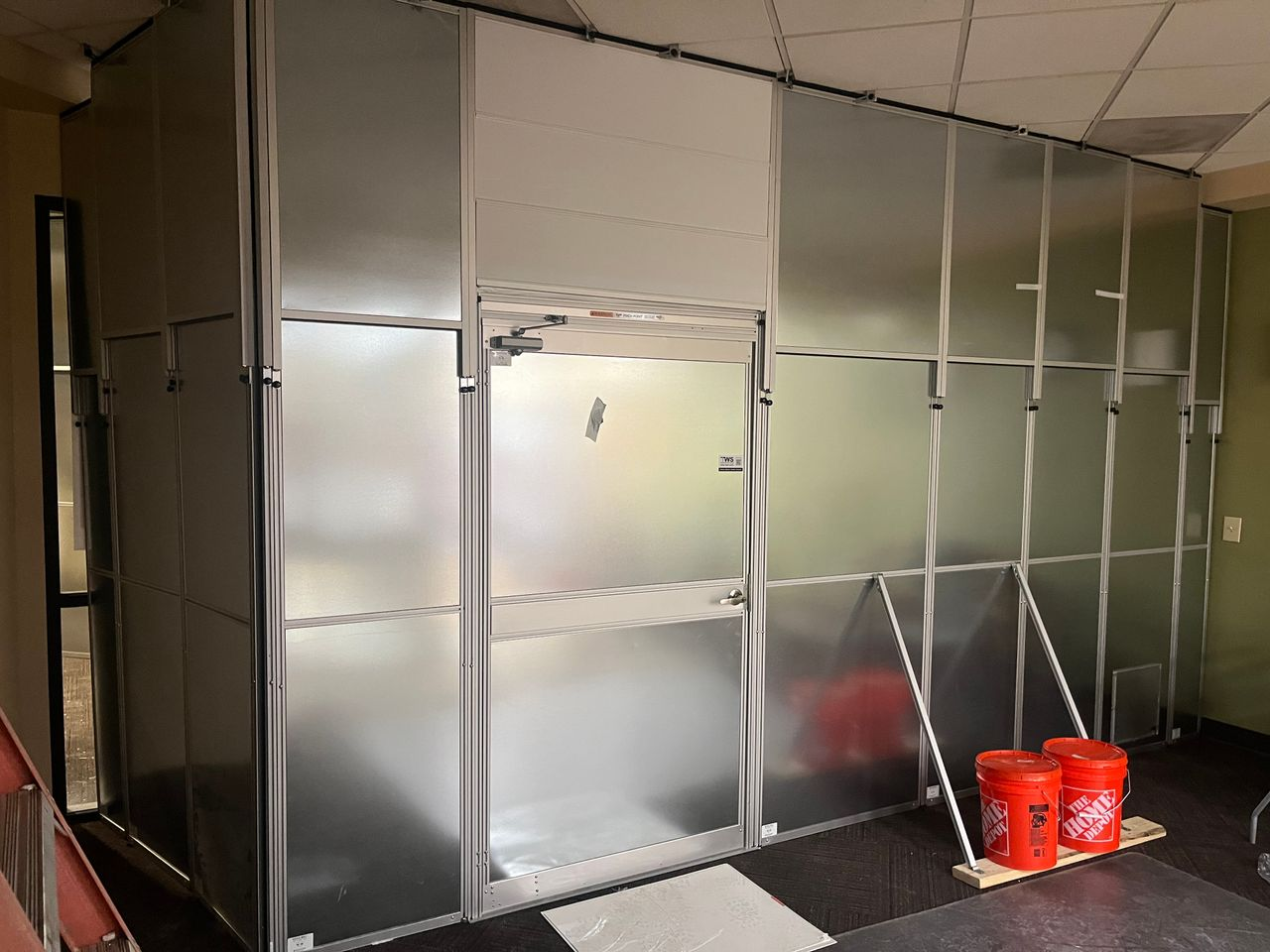 Modular temporary construction walls with an integrated access door enclosing a multi-phase renovation area inside North Idaho College's Student Union Building.