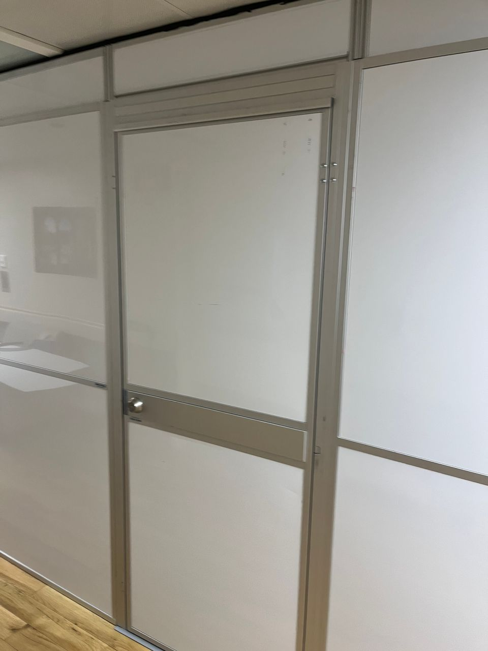 Reinforced modular hard wall containment with an integrated access door installed by Temporary Wall Systems for a behavioral health patient room renovation at the Mann-Grandstaff VA Medical Center.