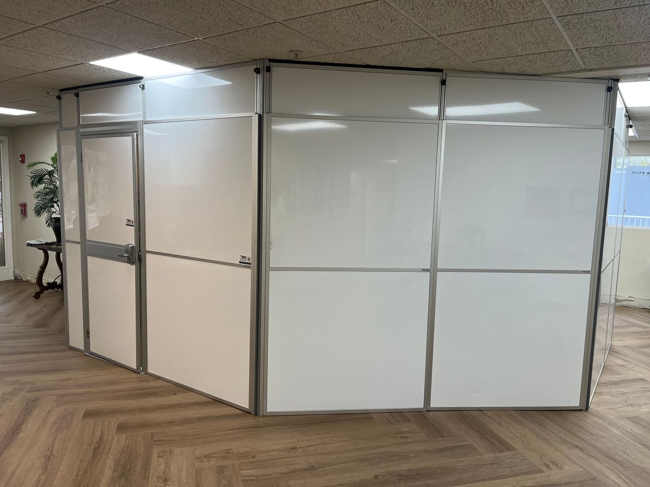 Modular hard wall containment with an integrated access door installed by Temporary Wall Systems for an assisted living lobby renovation to separate residents from active construction.