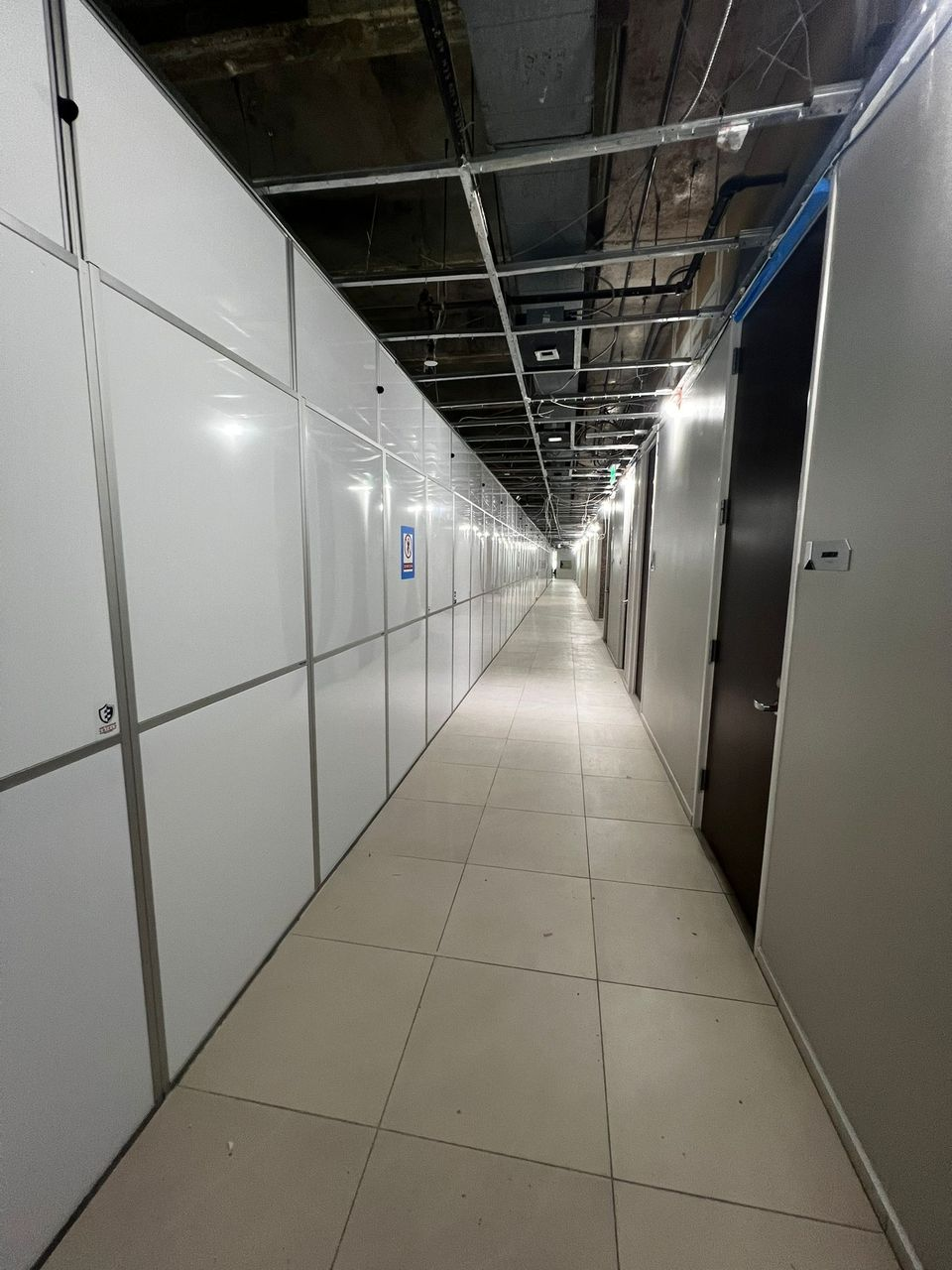 Long run of Temporary Wall Systems modular hard wall containment separating an active renovation area from a corridor at Galleria Office Tower I.