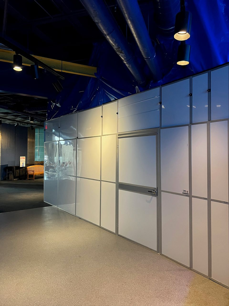 Temporary Wall Systems hard wall containment with integrated access door used for aquarium renovation containment in an occupied exhibit space.