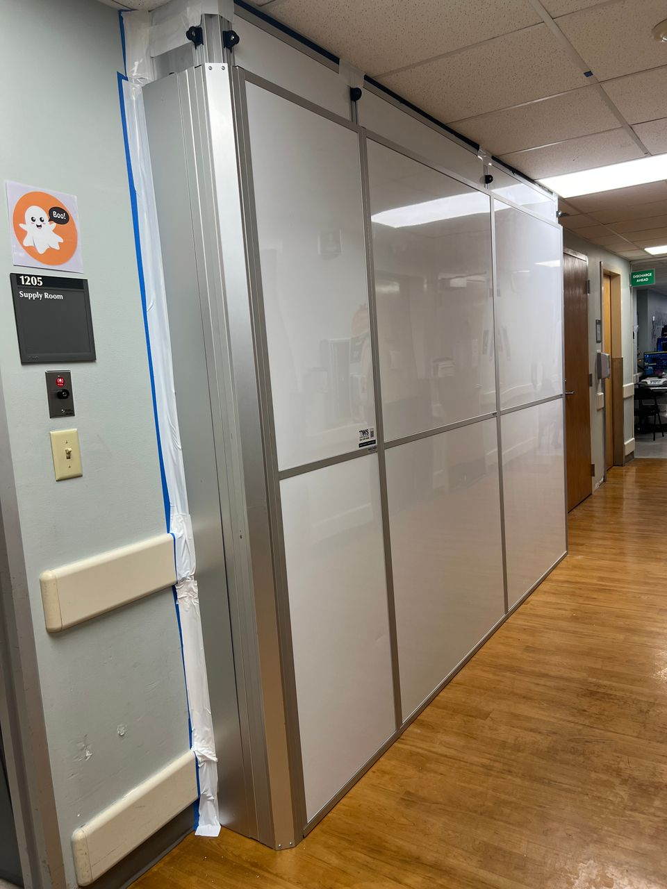 Healthcare construction containment using modular temporary walls in a narrow hospital hallway to support dust control and patient safety during renovation work.