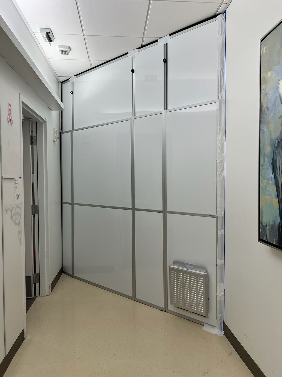 Healthcare construction containment wall with negative air filtration and modular temporary walls installed inside active hospital corridor