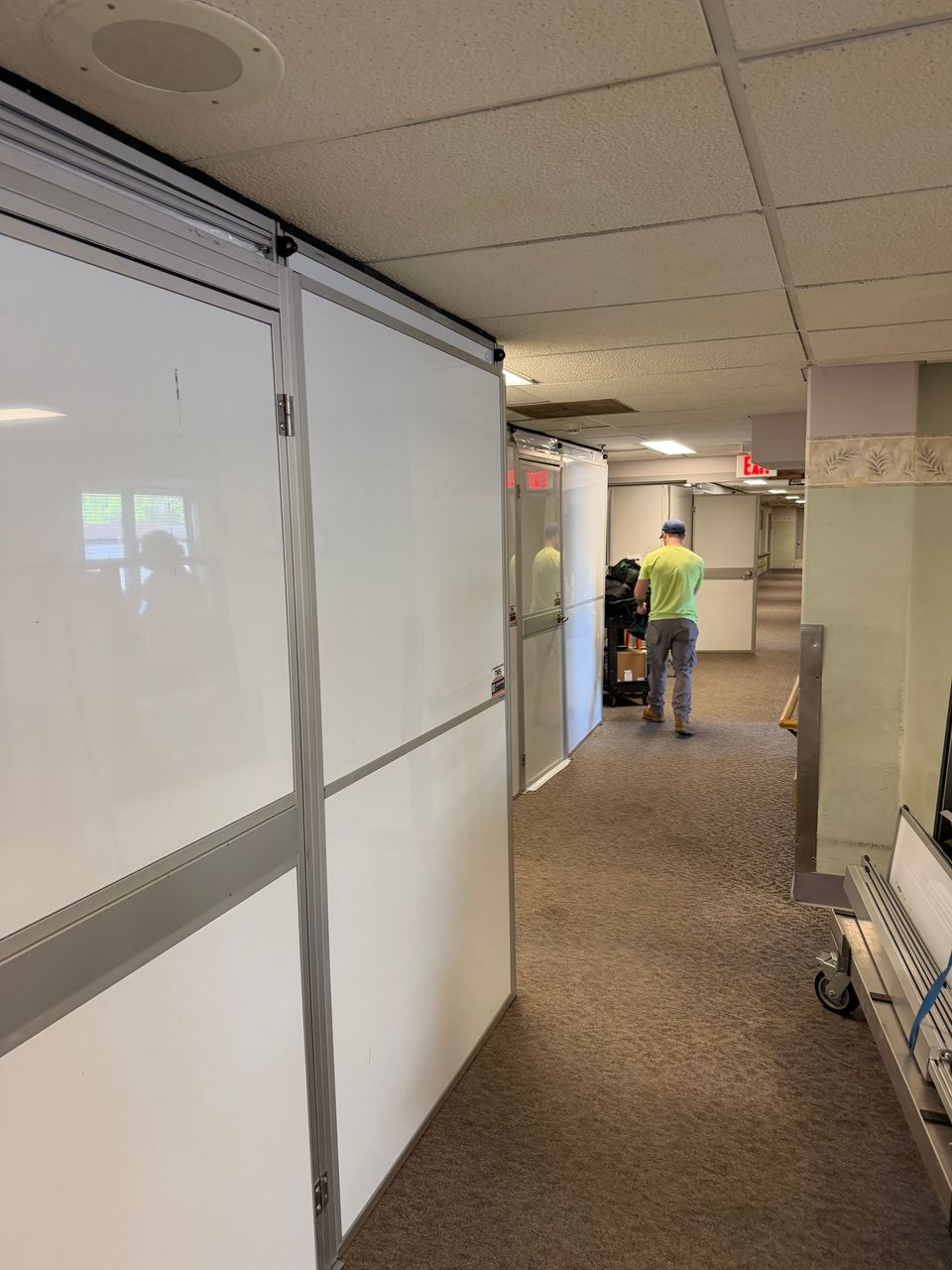 Healthcare construction containment wall with integrated access door creating a secure work zone during renovation while maintaining hallway access for staff and residents.