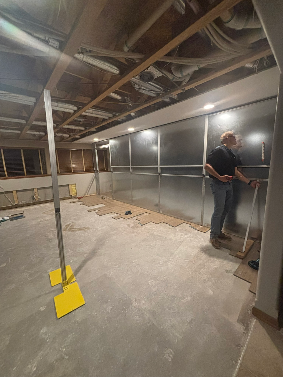 Temporary Wall Systems modular hard wall containment installed in a residential basement renovation project in Wichita, Kansas, isolating drywall and ceiling work while supporting construction dust control.