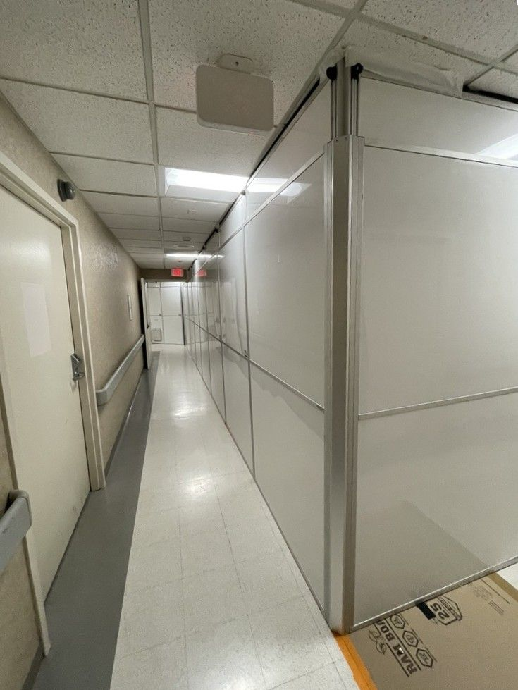 Temporary Wall Systems modular hard wall containment installed along an occupied education facility corridor to separate renovation work from active building operations.