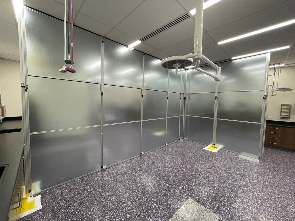 Interior view of temporary surgery area enclosed with modular hard wall containment panels in a veterinary education facility renovation project.
