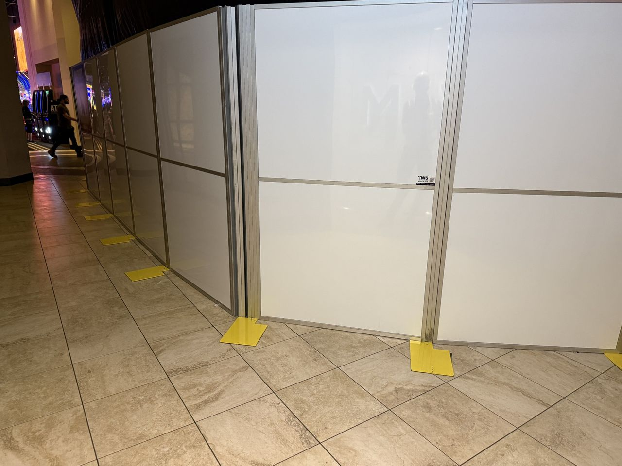 Construction containment wall reconfigured for a new renovation phase while preserving pedestrian traffic flow in an occupied casino environment.