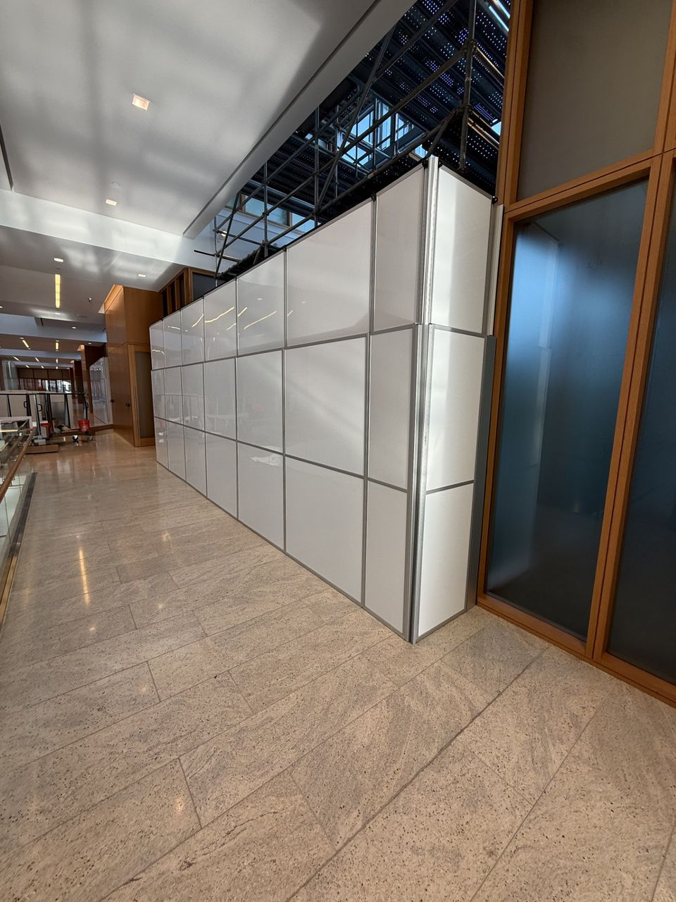 Temporary construction wall system with a clean professional appearance supporting office renovation containment in a corporate environment.