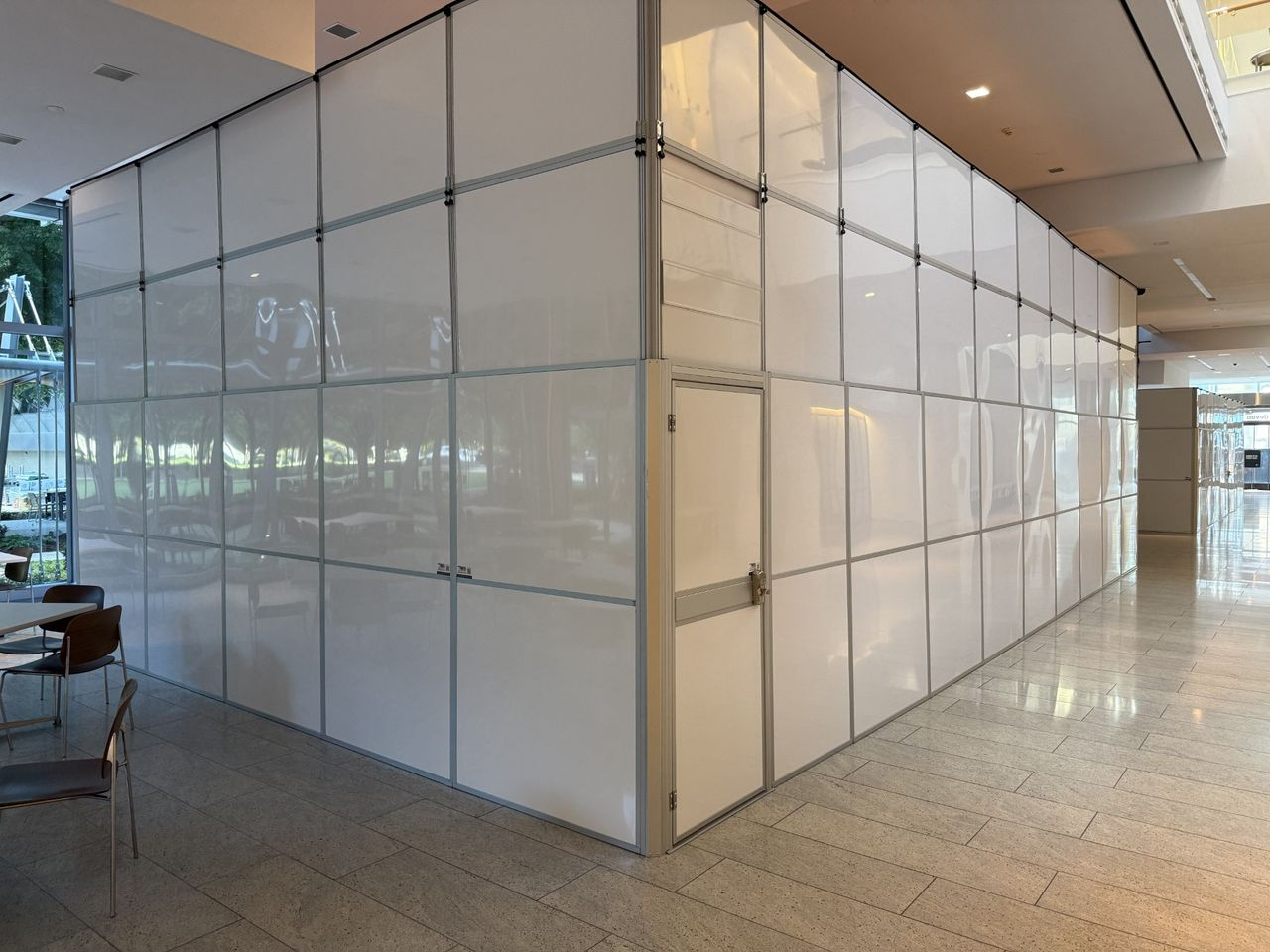 Modular hard wall containment system with access door installed around interior scaffolding during a commercial office building renovation.
