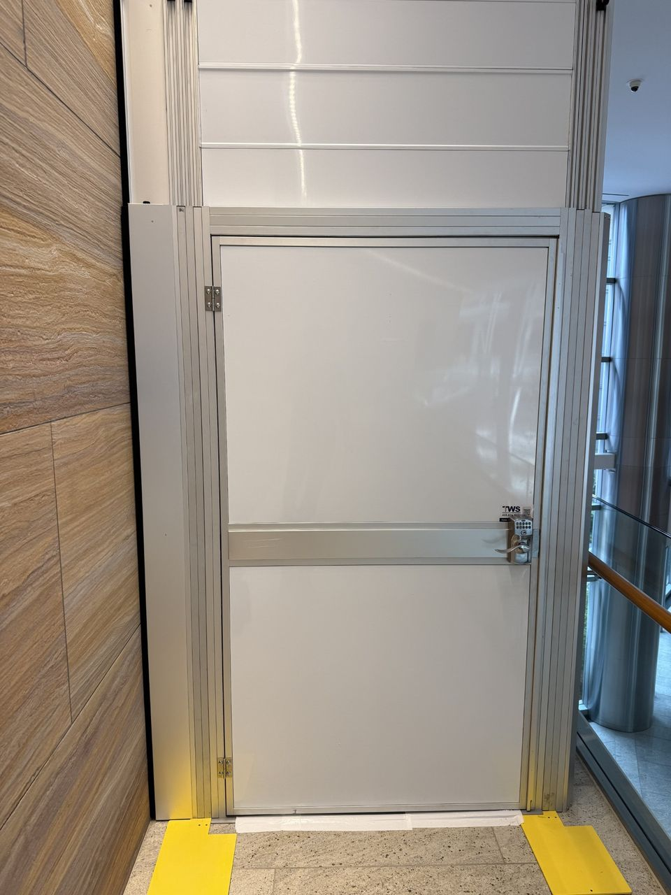 Construction containment access door and hard wall system protecting surrounding commercial office spaces during an occupied tenant improvement project.