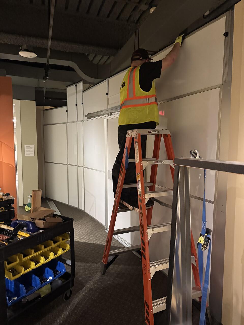 Hard wall containment surrounding exhibit renovations for protective glass replacement in an active museum