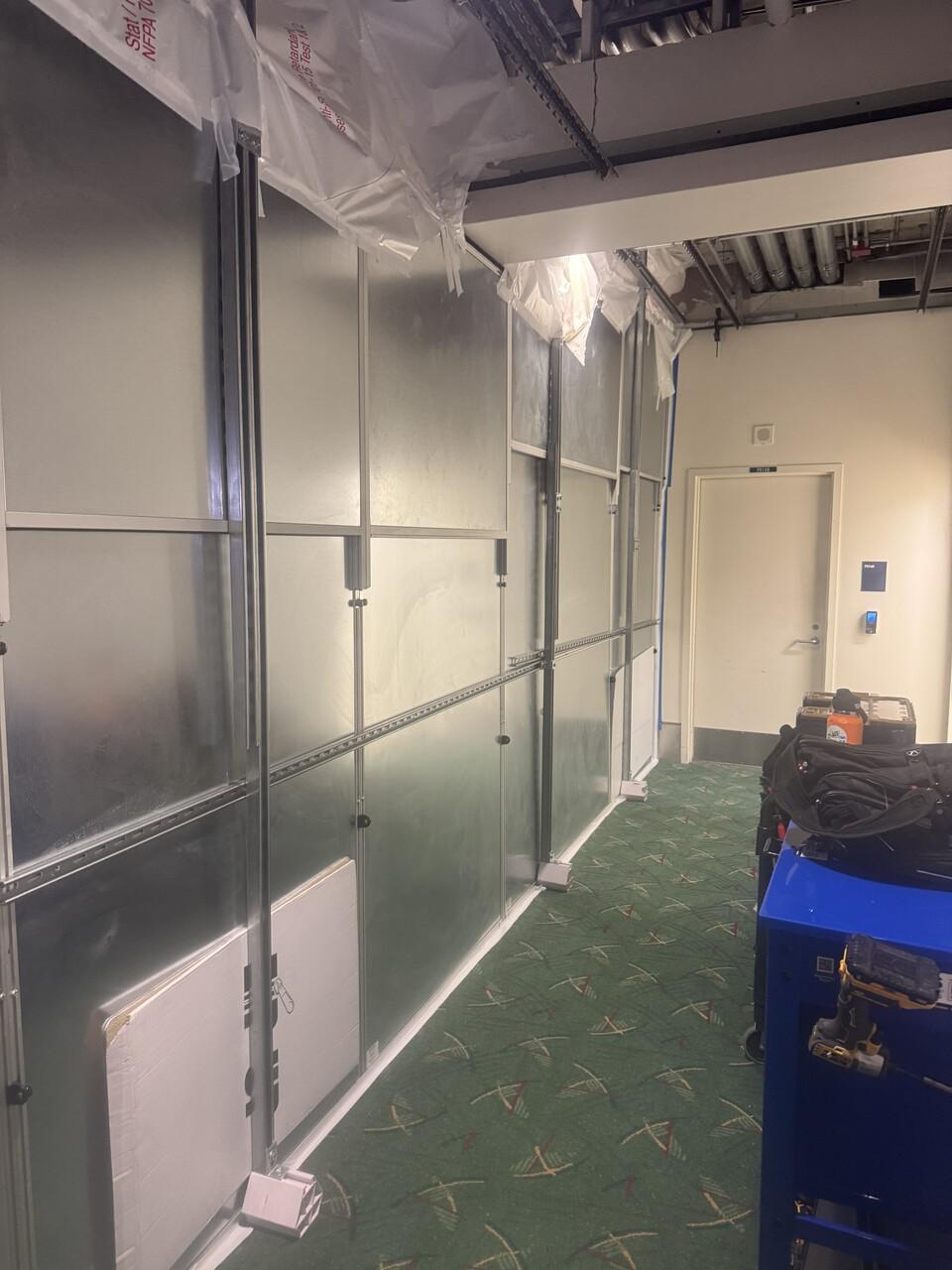Containment wall sealed around exposed infrastructure above ceiling during airport renovation