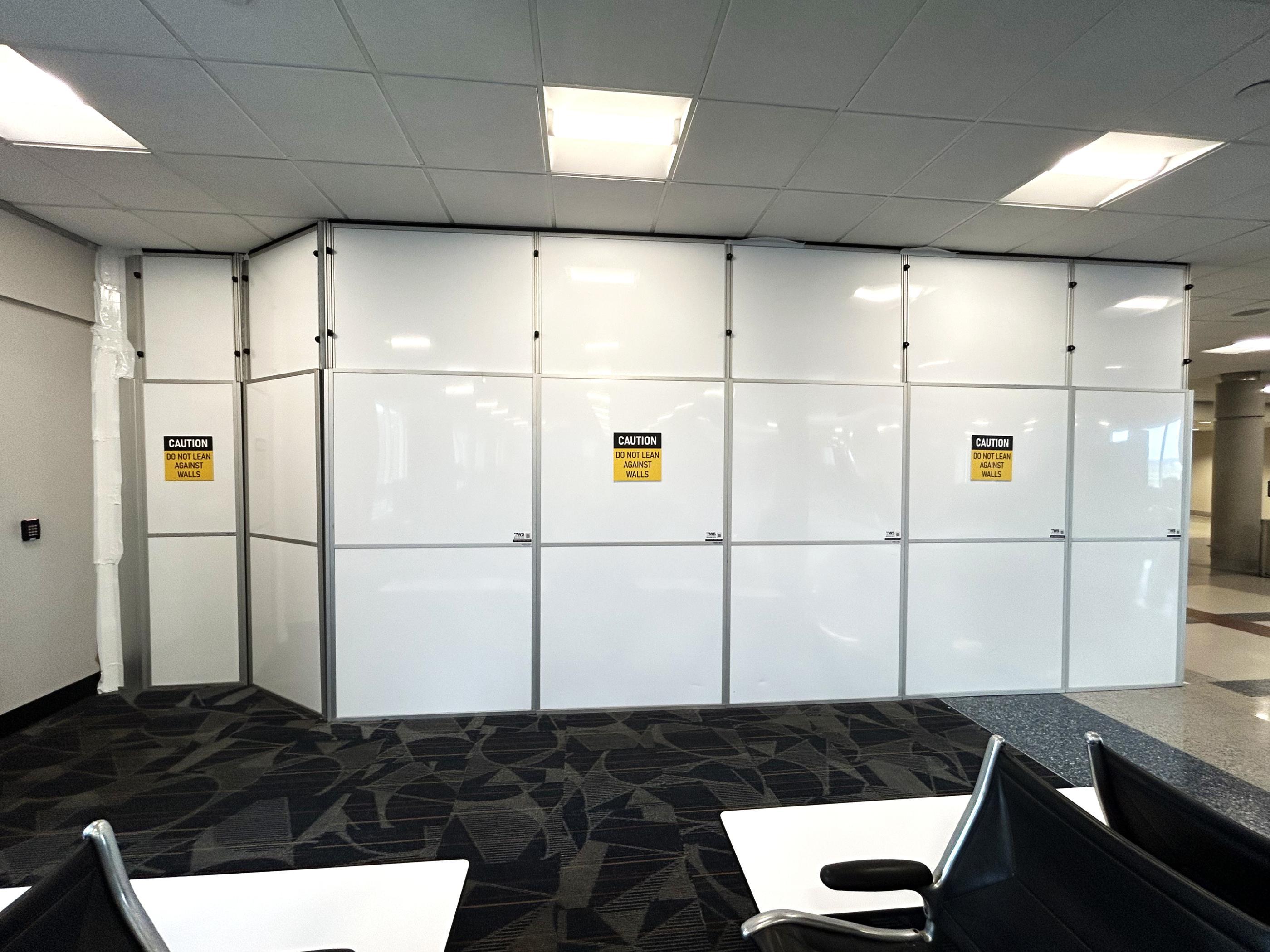 Modular construction containment extending along Concourse B during women’s and family restroom renovations.