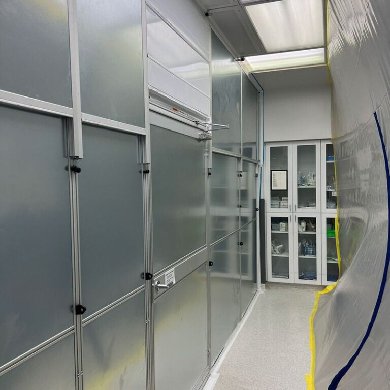 Custom modern laundry room with white storage cabinetry, a large basin sink, countertop folding space, and a rod for hang drying clothing