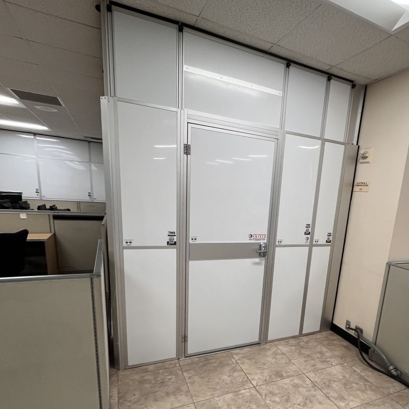 temporary wall with a door in an office next to a gray cubicle