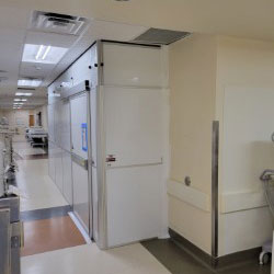 Custom modern laundry room with white storage cabinetry, a large basin sink, countertop folding space, and a rod for hang drying clothing