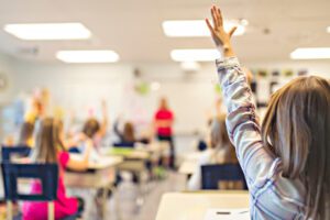 child raising hand in class