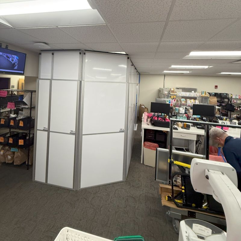 temporary wall in a hospital with totes and shelving around it